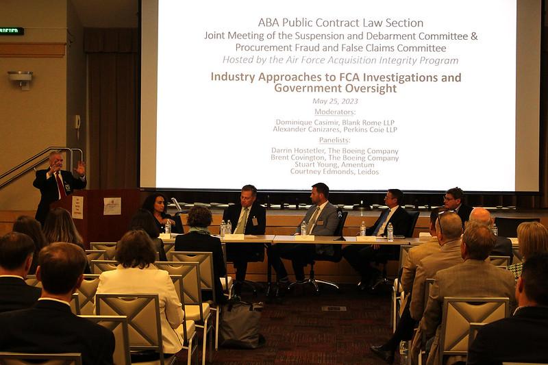 Panelists in front of presentation title slide at Industry Approaches to FCA Investigations on May 25, 2023